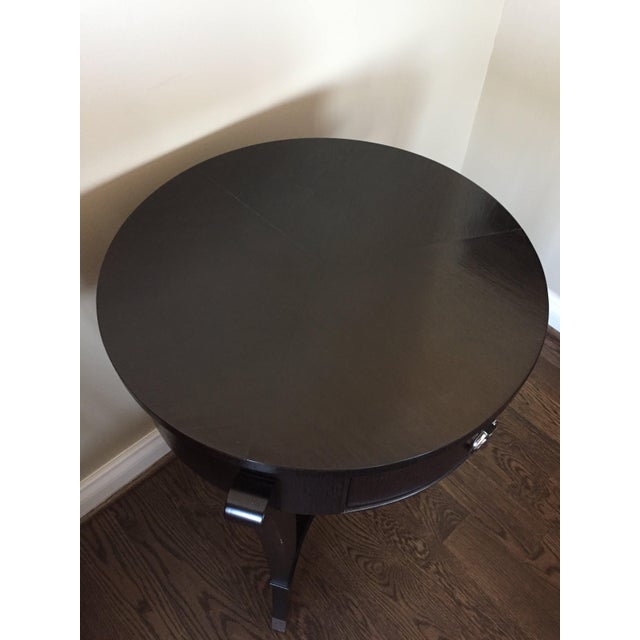French Art Deco inspired round table with (3) arced legs made of mahogany veneers and solids with nickel ring pull and...