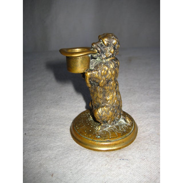 This lovely Thimble holder is air bronze and represent a dog holding a hate in is mouth were the thimble would be place ,...