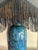 Deep teal/cobalt body with striking natural veining—highly polished and set on a hardwood plinth. Brass fittings; works...