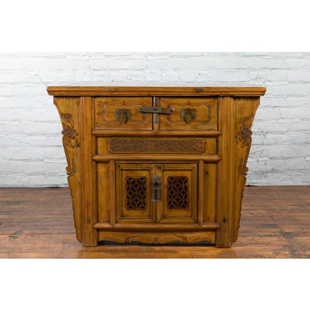 A Chinese Qing Dynasty wooden console cabinet from the 19th century, with carved spandrels and two drawers over double...