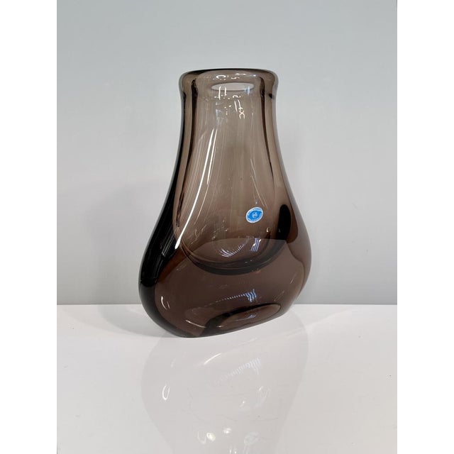 An elegant, sculptural glass vase made of heavy Bohemian smoked glass with a softly rounded silhouette and a distinctive...