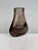An elegant, sculptural glass vase made of heavy Bohemian smoked glass with a softly rounded silhouette and a distinctive...