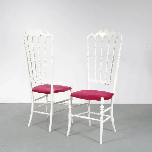 A beautiful pair of white wooden chairs in a highly recognizable Italian style. Manufactured by Chiavari. The chairs have...