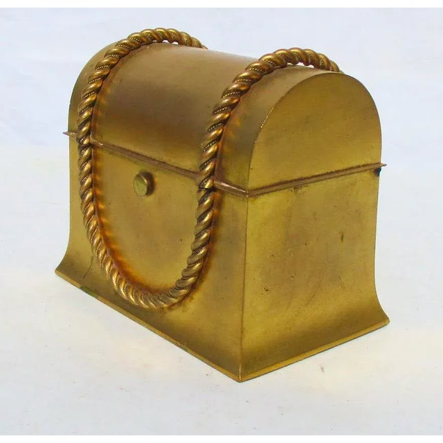 Gilt metal perfume chest with modern silk lining. Smooth satin gold finish over a high domed lidded chest with rope braids...