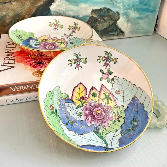 Pair of porcelain bowls in the Tobacco Leaf pattern with shiny brass casing and hooks to hand on a wall.