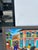 Striking vintage Haitian acrylic painting on board of a busy street scene executed and a distinctive naïve style, signed...