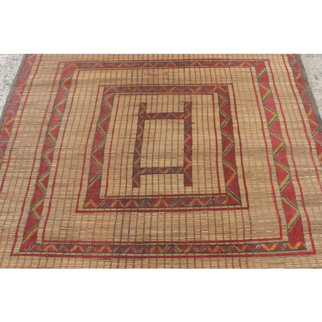 Made with handwoven reed and camel leather in Mauritania circa 1950-1960, this 4x4 vintage square Tuareg mat is an...