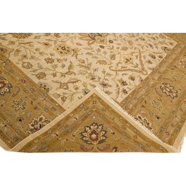 Beautiful Paki Peshawar hand-knotted wool rug with a beige color field. This modern rug has a brown designed frame with...