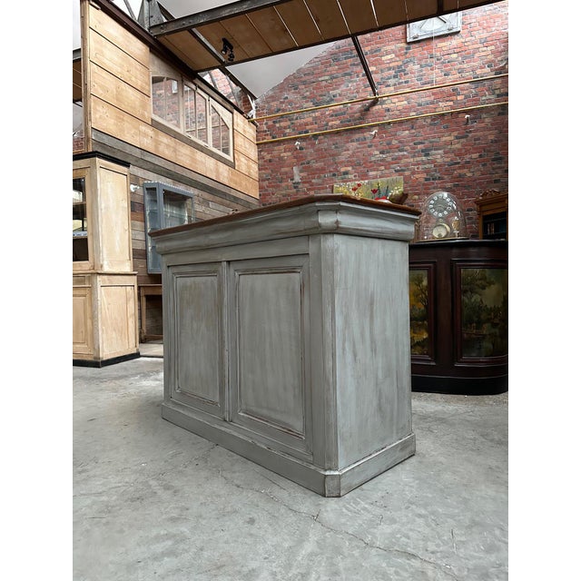 This old cherry wood bar counter has been completely restored. It consists of a gray patinated cabinet and a raw wood top....