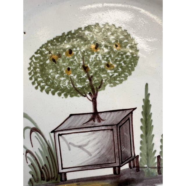 French earthenware plate from Nevers from the end of the 18th century, decorated with a fruit tree in a stylized pot....