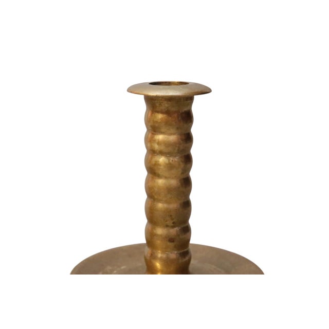 A pair of trumpet shaped polished brass candlesticks by Colonial Williamsburg, with turned and ribbed columns, wide drip...