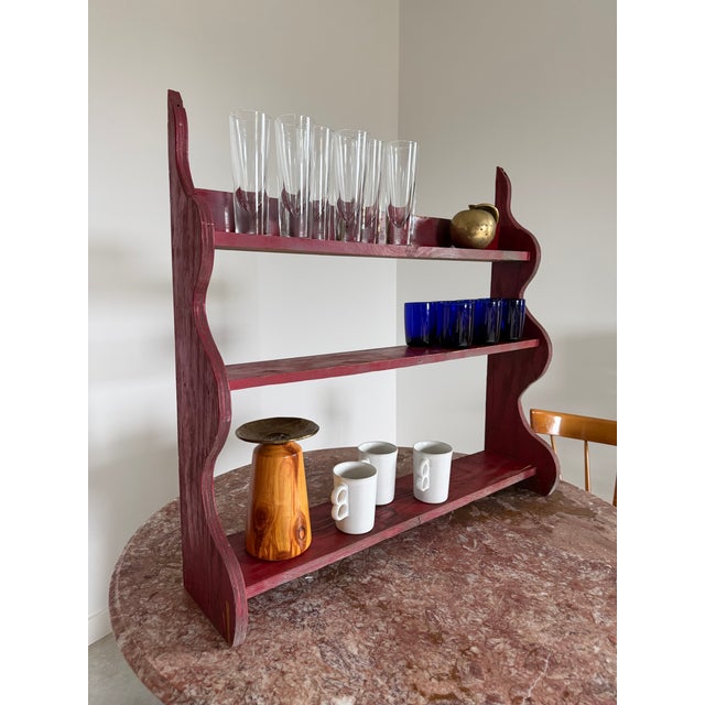 A red-painted primitive, counter-mounted shelf. The perfect size and depth for a small collection of pottery or design...