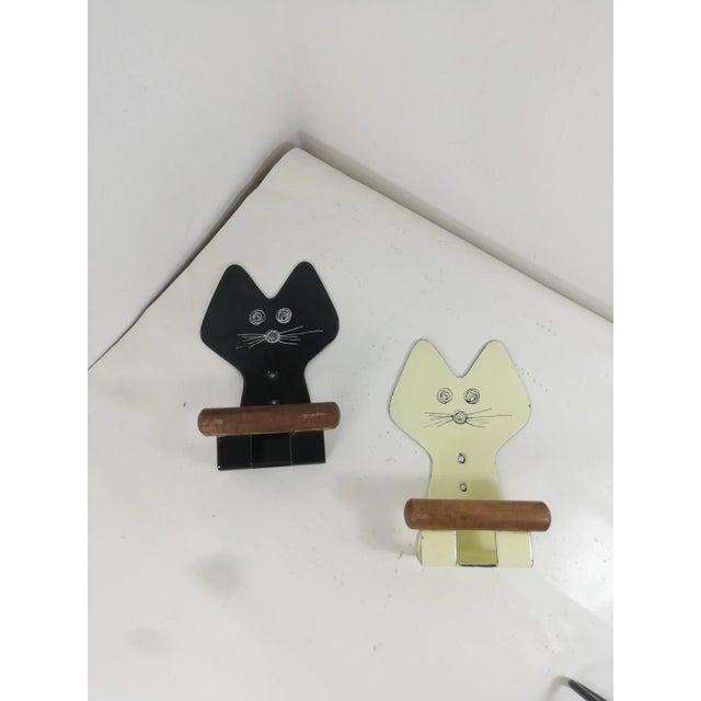 Pair of wall-mounted clothes racks in enamelled metal and wood. Original decorations and original colors. Easy to install,...