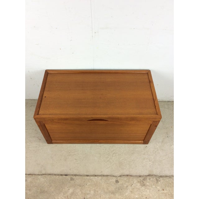 This Danish style blanket chest features teak construction, original teak finish, carved wood handle on the lid, and brass...