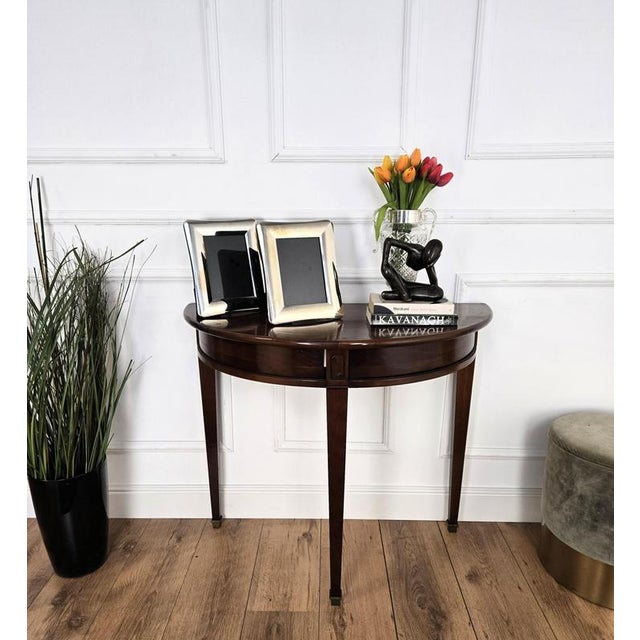 Very elegant and refined Italian Mid-Century Modern design console side table. Standing on three typically carved wooden...