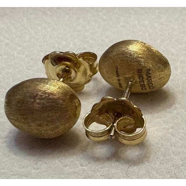 Gorgeous 18k yellow gold designer stud earrings with a satiny finish. These oval shape hand engraved earrings add a touch...