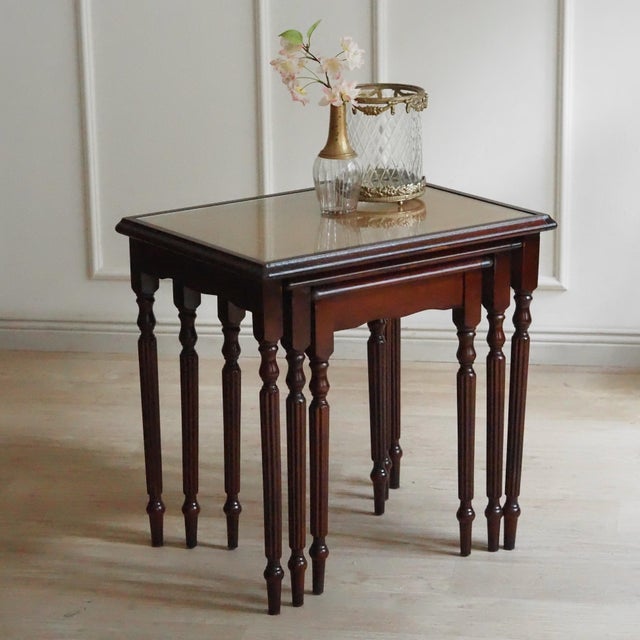 Three-piece mahogany nesting table set in the English Regency style, crafted in the second half of the 20th century. The...