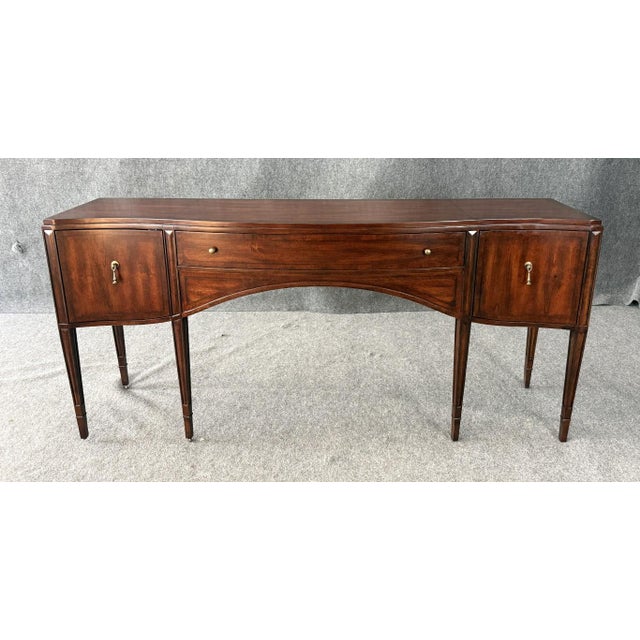 This Hooker Furniture Charleston console table sideboard showcases a refined, serpentine front with tapered legs, paneled...