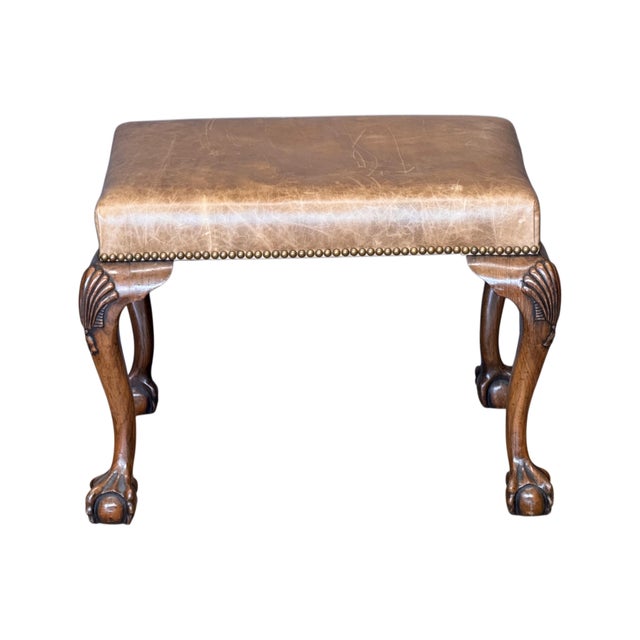 A mid-19th C. English Chippendale style carved mahogany stool with leather-upholstered seat above cabriole legs. The legs...