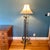 This impressive standing lamp features an off-white bell shade and three scrolled legs adorned with acanthus leaves. The...