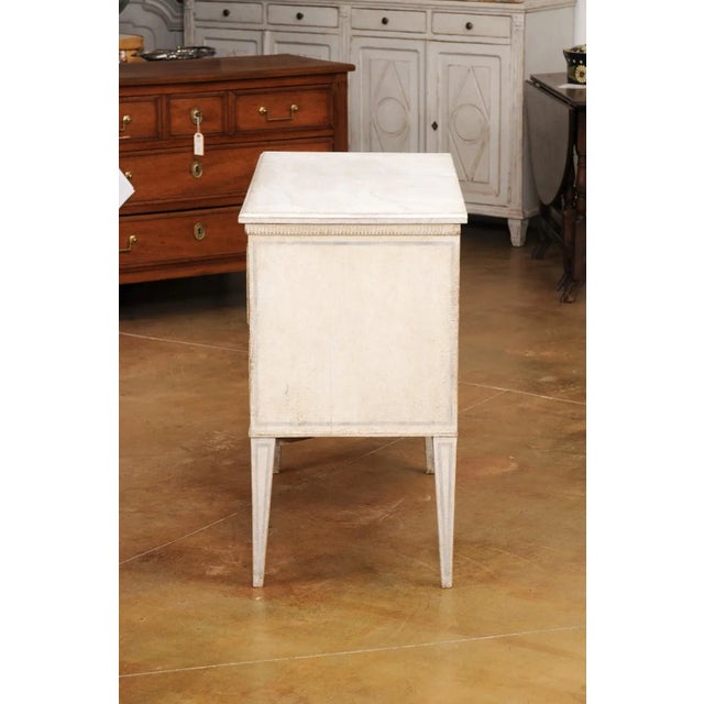 A Swedish Gustavian style painted chest circa 1890 with two drawers, carved fluted molding, light grey painted outlines...