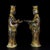A striking pair of Chinese bronze figural sculptures, likely used as lamp holders or candle stands. Each figure depicts a...
