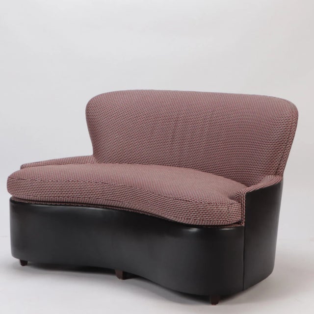 A curved sofa. Solid frame and legs. Upholstered in fine leather and fabric from Spinneyback. Designed for a private...