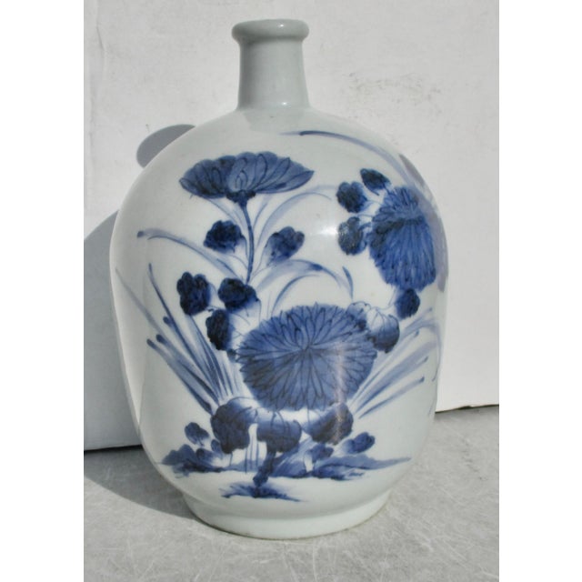 Celadon body with an ink blue floral spray across the front and a pair of butterflies in flight on the back side. A...