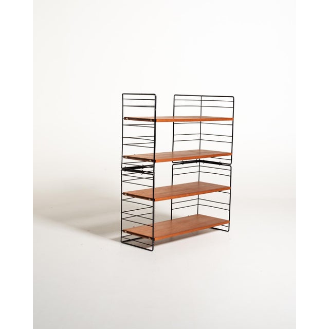 Freestanding modular and removable bookcase with black lacquered metal uprights and four adjustable teak shelves....