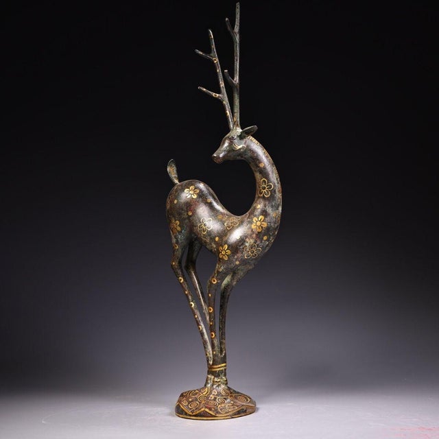This striking antique bronze sculpture depicts a standing deer, a traditional symbol of longevity, wealth, and good...