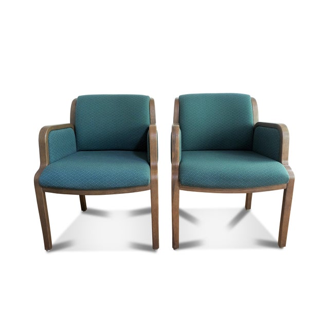 A pair of Thonet bentwood arm chairs. The modern armchairs are a dark oak with a unique bentwood frame and green...