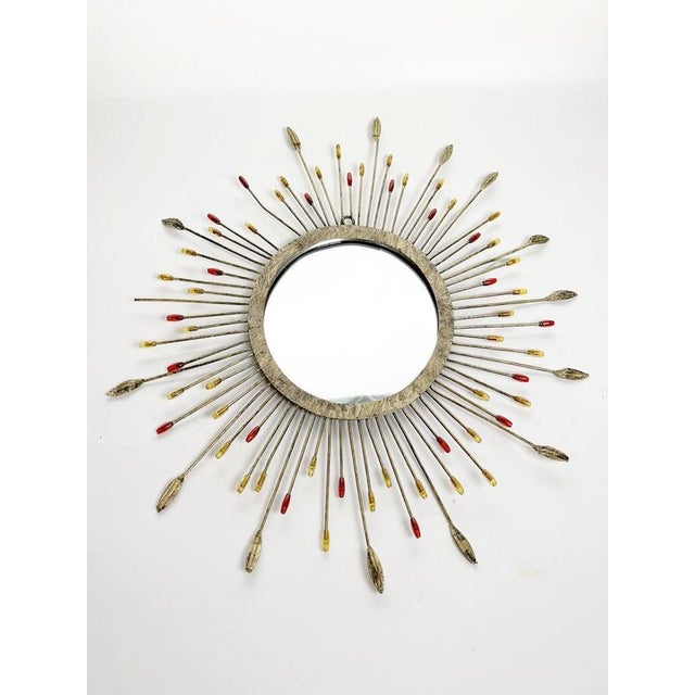 French decorative wall mirror dating from the 1970s, featuring a circular central mirror surrounded by a radiating metal...