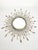 French decorative wall mirror dating from the 1970s, featuring a circular central mirror surrounded by a radiating metal...