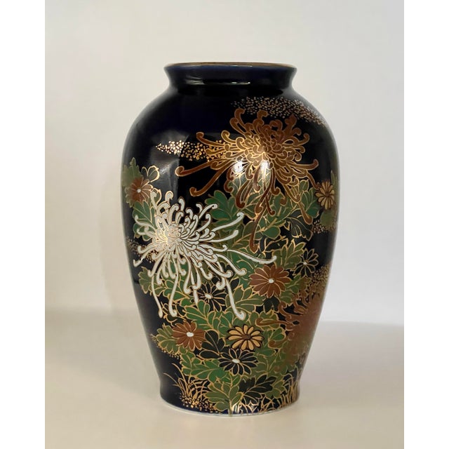 A mid 20th century dark blue vase decorated with a collection of stylized flowers in the Kutani style.