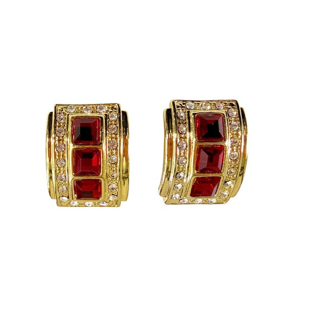 Vintage clip-on earrings featuring elegant goldstone and rhinestone settings. Each piece showcases a striking three square...