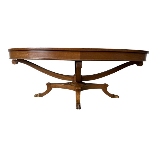 1960s Hollywood Regency Neoclassical Style Mahogany Oval Coffee Table With Brass Claw Feet For Sale