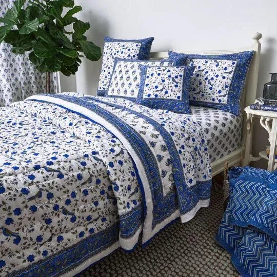 The celebrated Birds on Vine design displays a whimsical pattern of birds perched on flowering vines, set against a...