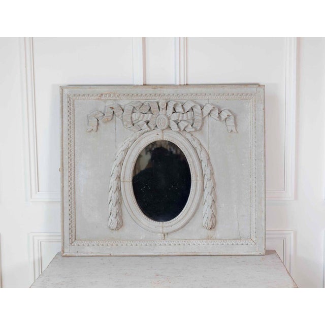 An elegant 19th century French boiserie panel featuring a beautifully carved neoclassical design centered around an oval...