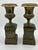 Pair of brass urns on pedestals. Bronze colored pedestals with repousse copper plaque with classical scenes. 20th century....