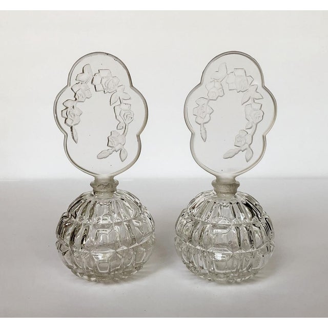 Elegant vintage pair of Irice optic glass vanity dresser perfume bottles with crystal cut intaglio rose blossom stoppers....