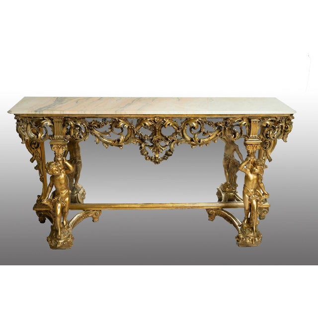 Richly carved console table with integrated mirror in Baroque style, dating back to the early 1970s. The mirror features...