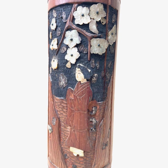 Handcrafted Japanese Shibayama-style cylindrical vase or decorative container, featuring a figural scene beneath flowering...