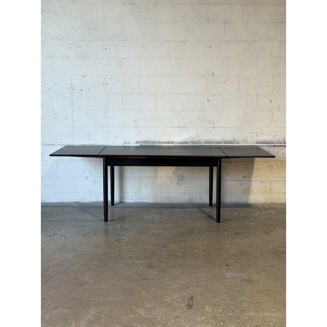 Beautiful vintage Danish Modern extendable dining table crafted from teak and refinished in a rich, dark stain that brings...