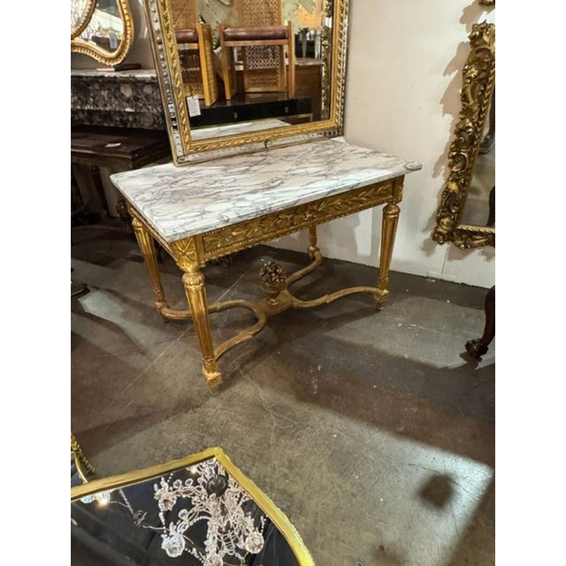 This 19th century French Louis XVI giltwood center table is a stunning addition to any space. Made of carved wood with...