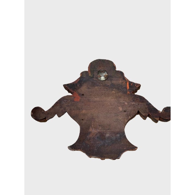 A sculptural giltwood decorative fragment featuring scrolling Rococo-style detailing and a central oval cartouche. This...