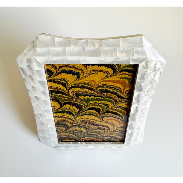 This elegant tabletop picture frame features tessellated mother-of-pearl and a sinuous shape. Crafted using an inlay...