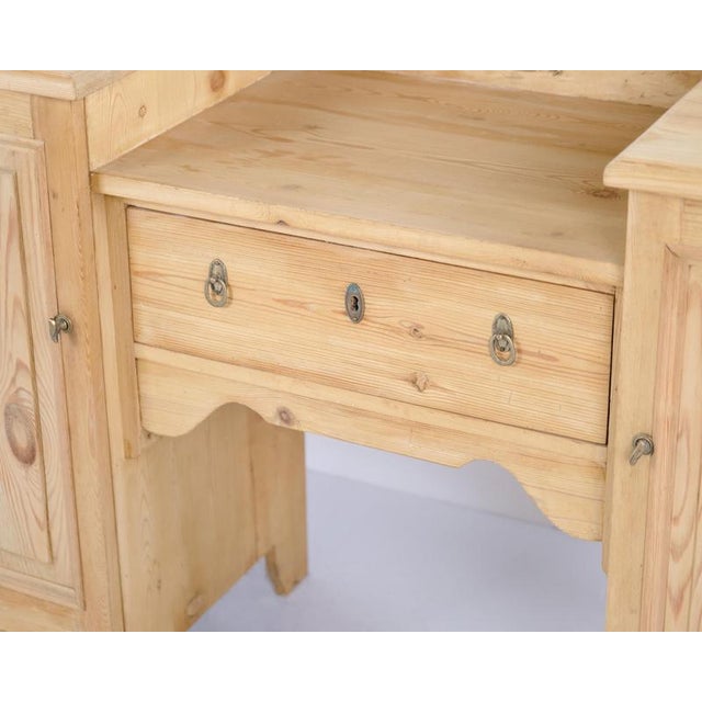 Dressing table made of pine in Denmark around the 1920s. The piece features a mirror and tabletop space for storage and...