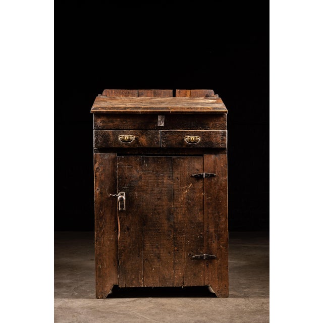 Early American standing desk constructed from wide, rough-sawn wooden boards with a deeply worn dark finish and...