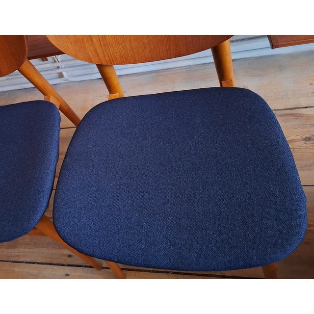Set of 6 dining chairs in teak and beech, the seats recently re-covered with a structured navy blue fabric similar to...