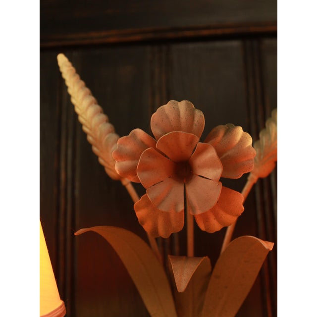 Vintage two-light wall sconce made of painted metal with an elegant floral design. A decorative piece with romantic,...